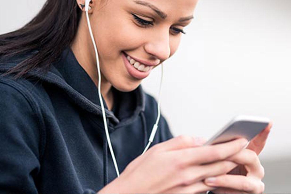 Girl looking at phone with headphones