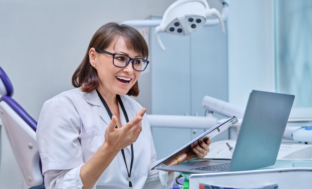 A female dentist on a computer talking to a patient via a teledentistry appointment